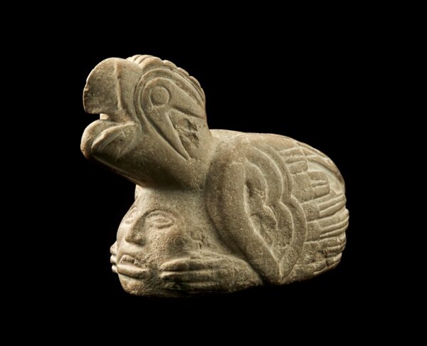 A small sculptural pipe of a human head with a raptor on top, like a hat