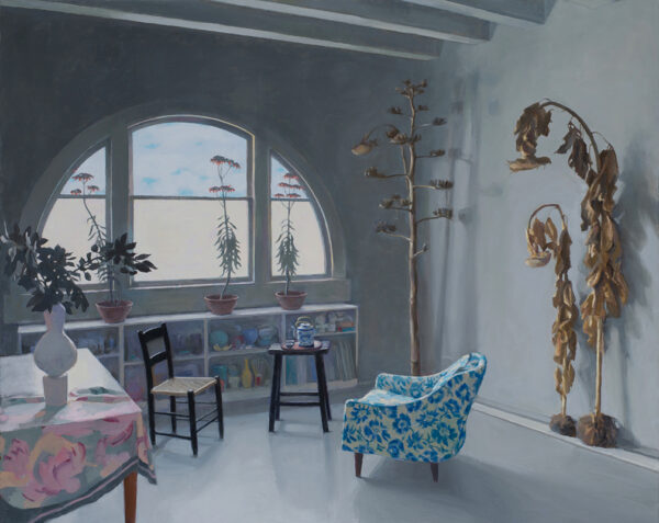 A painting by Carol Ivey of her Lancaster Loft studio. The painting shows an arched window with a short bookcase below it. There are two chairs set facing each other and small table with a teapot. Large dried plants stand against one wall.