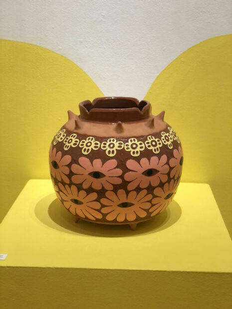 Photo of a ceramic vessel with flowers and white details