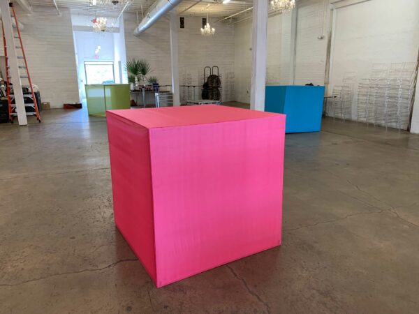 Brightly colored, fabric-covered cubes sitting in a warehouse type space.