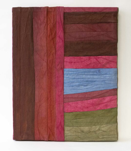 A sculpture made of may different pieces of red, blue, and green fabric.