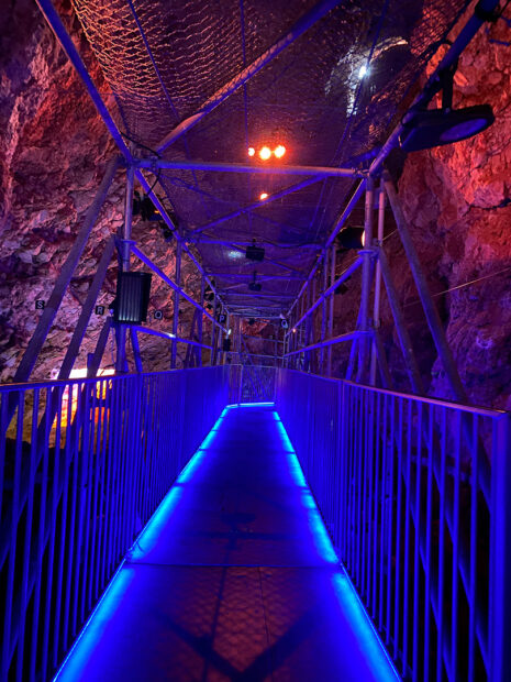 A photograph of the interior of the Lazaret Cave with blue lights lining the walkway.