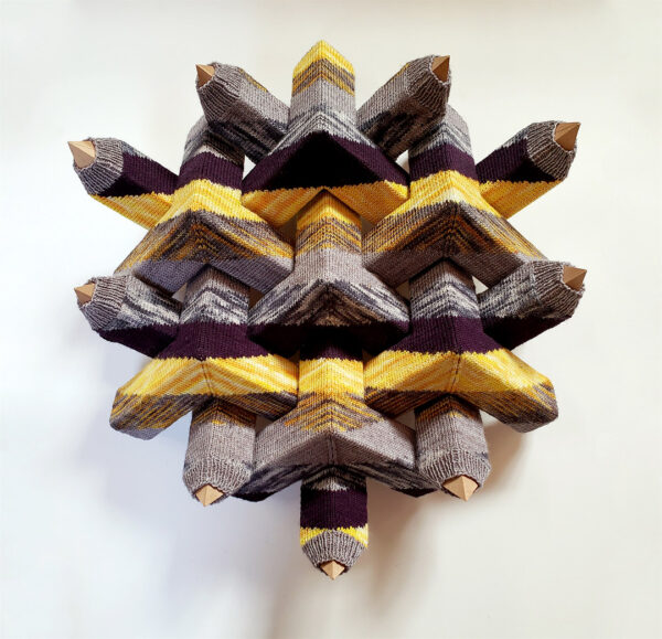 A sculptural work by Rusty Scruby featuring interlocking wooden pieces with a knitted slip over it.