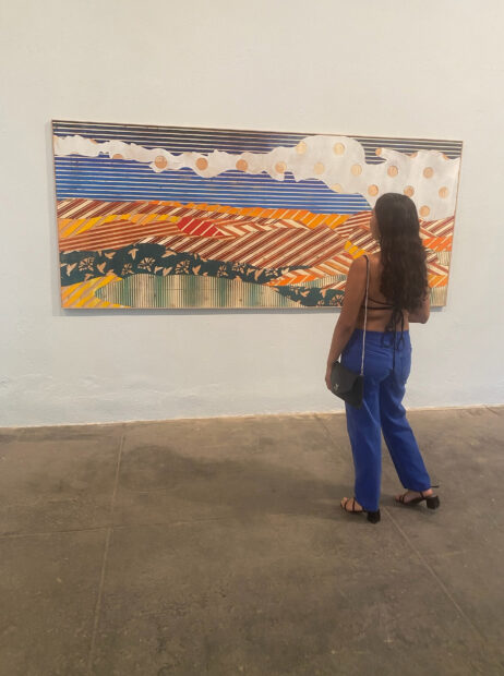 A viewer looking at a painting by artist Zeke Williams