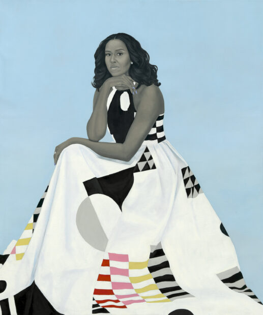 Portrait of Michelle Obama wearing a white dress with geometric patterns agains a blue backdrop