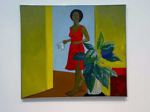 A self-portrait by Emma Amons. Amons is depicted wearing a red dress and framed by a doorway. She holds a glass measuring cup with water in her hand and a a plant sits in the foreground.