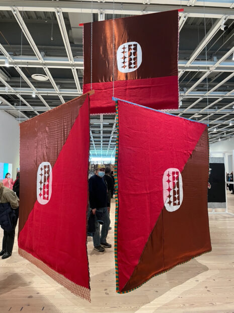 Installation of red and brown flags suspended in a gallery
