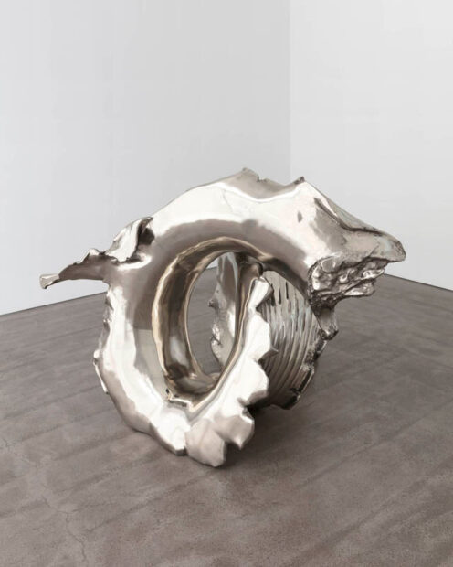 A bronze work by Lynda Benglis. The curled form looks silver and organic resembling in some ways an elephant's foot. 