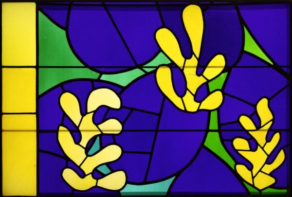 A stained glass window study featuring three yellow organic forms in front of a handful of blue-violet oval forms. There is a green background and on the left side is a vertical yellow rectangle.