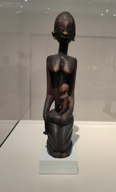 Wooden figure of a mother holding a child