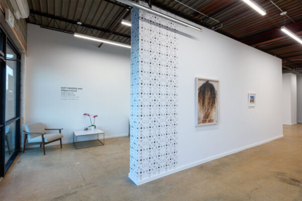 Installation view of an exhibition with black and white wallpaper and a photo on vinyl