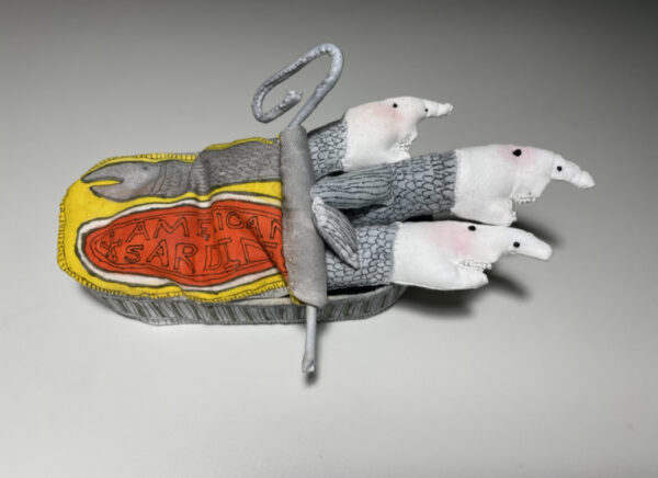 A small soft sculpture of three sardines in a partially opened can. Artwork by Barbara Rosenblatt.