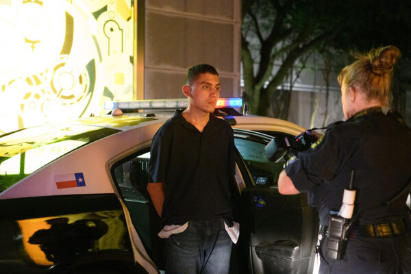 A Dallas Police Department crime scene analyst photographs Brian Hernandez outside the Dallas Museum of Art after he was apprehended Wednesday.