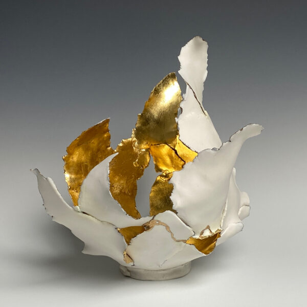 An abstract porcelain sculpture by Deneece Harrell Ham. The sculpture is made up of organic shapes. The inside of the sculpture is gold while the outside is white.