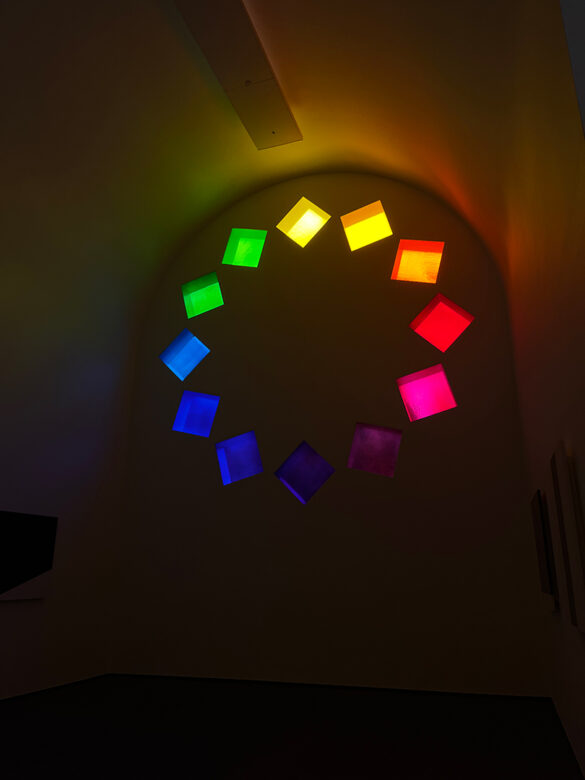 A photograph of the interior of Ellsworth Kelly's "Austin" showing a stained-glass window made from long thin rectangular pieces of colored glass.