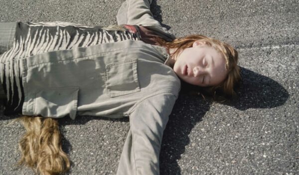 video still of a woman lying on pavement