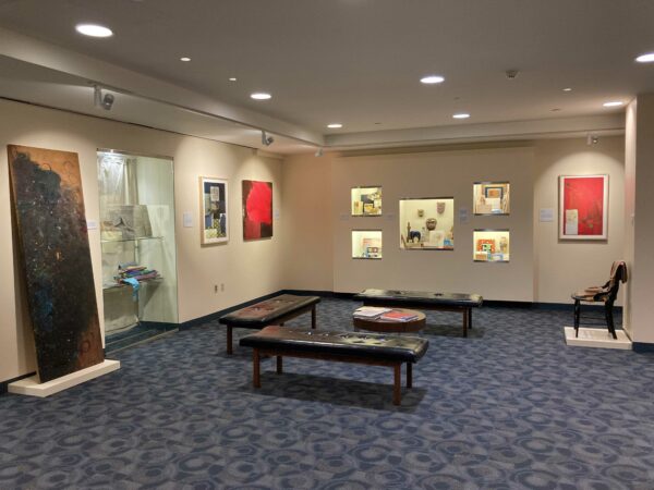 Exhibition installation view with various two dimensional works on the walls