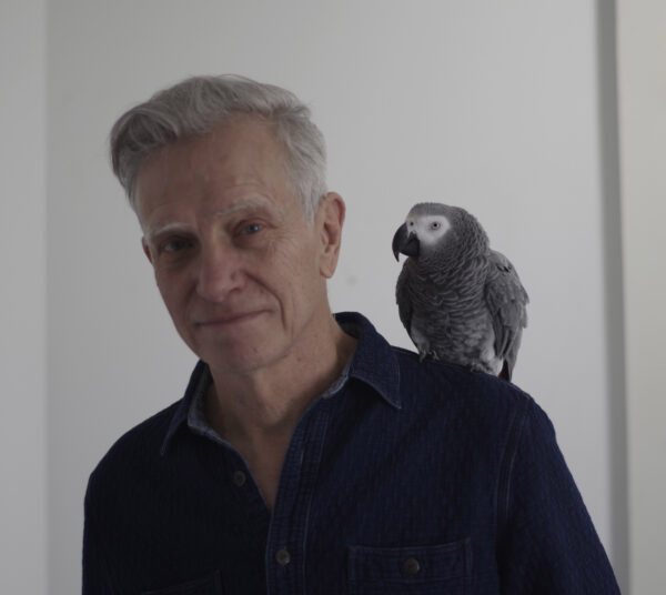 Artist and educator Joseph Havel with his pet parrot Hannah on his shoulder
