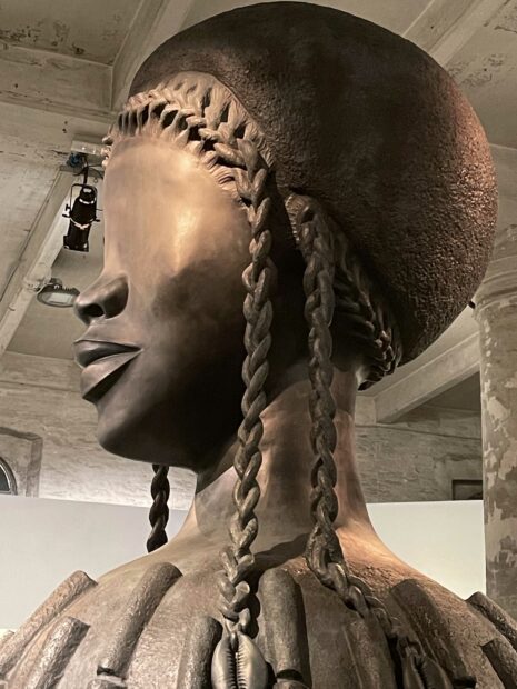 Large sculpture of a bronze figure with a female face
