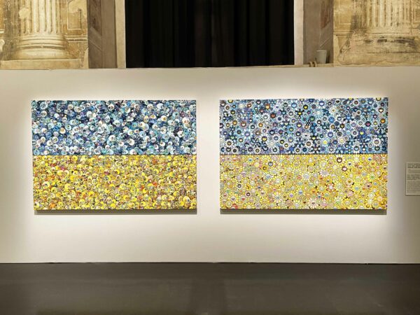 Installation image of a colorful blue and yellow painted diptych of flowers