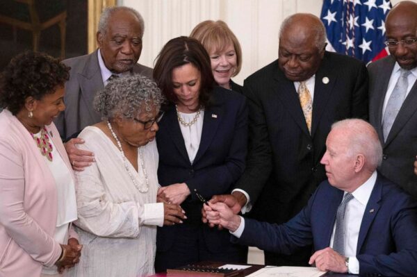 Vice President Kamala Harris watches as Opal Lee (2nd L), the activist known as the grandmother of Juneteenth, is given a pen after President Joe Biden signs the Juneteenth National Independence Day Act, in the East Room of the White House, June 17, 2021.