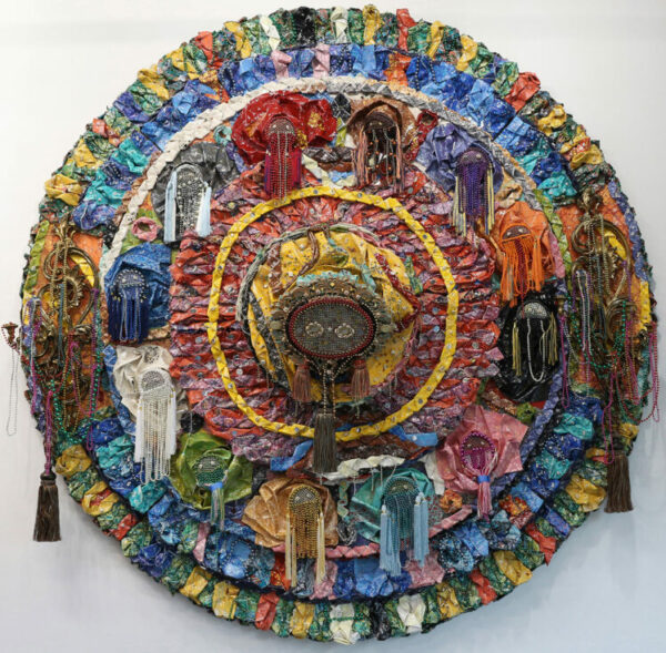 A mixed media tapestry sculpture by Olaniyi Rasheed Akindiya. The object is colorful and circular.