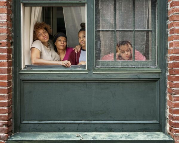 A photograph by Rania Matar of a family inside their home looking out the window.