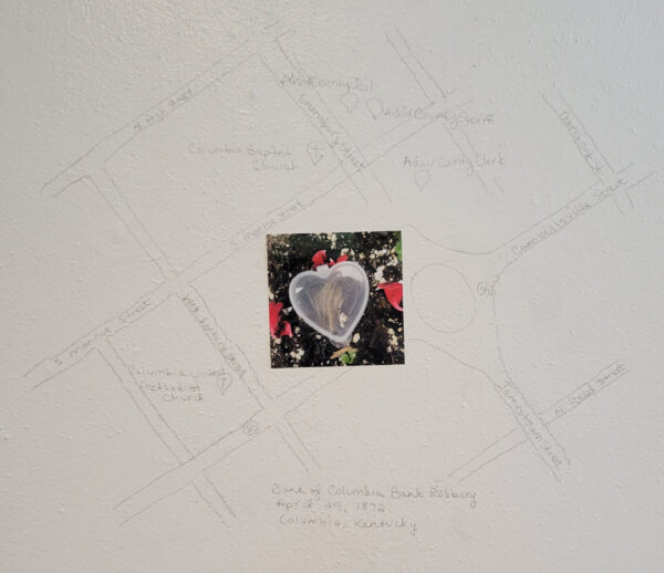 Installation view of a photo of a heart on a hand drawn map