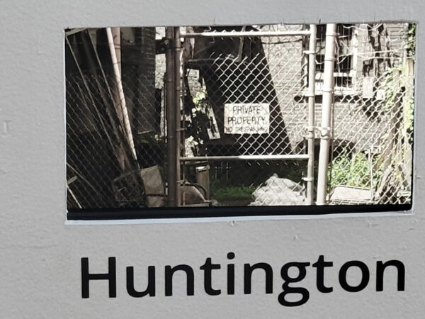Photo of a chain link fence with a sign that says "private Property" and the word "Huntington" in vinyl under