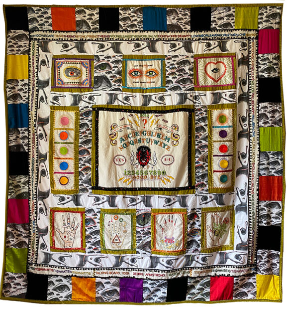 A large quilt by Debbie Armstrong featuring detailed embroidery of mystic iconography.
