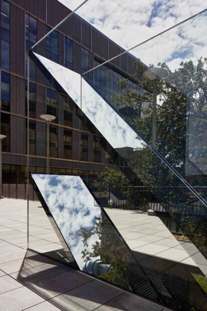 Detail of a sculpture with two panes of glass and two mirrors sandwiched between at an angle