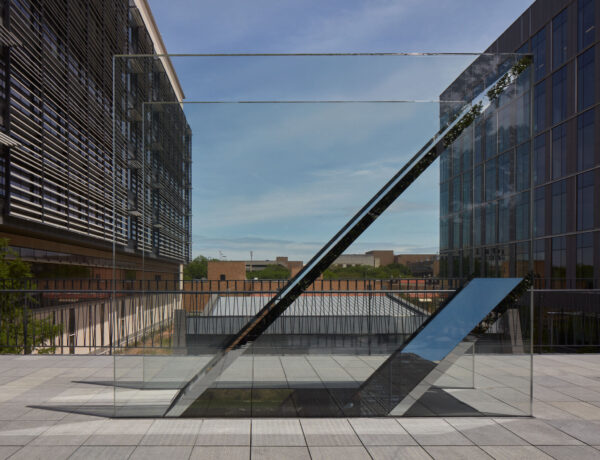Detail of a sculpture with two panes of glass and two mirrors sandwiched between at an angle