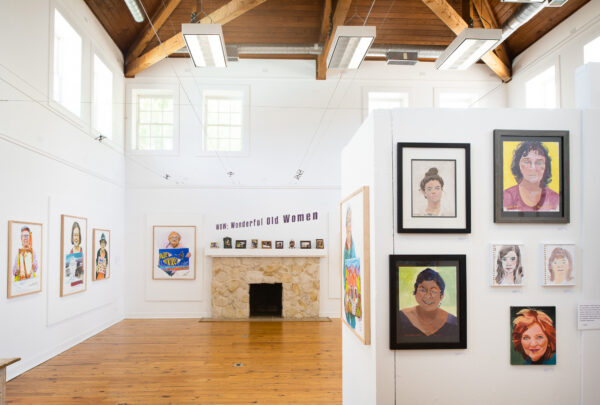 Installation view of portraits of women holding portraits of women