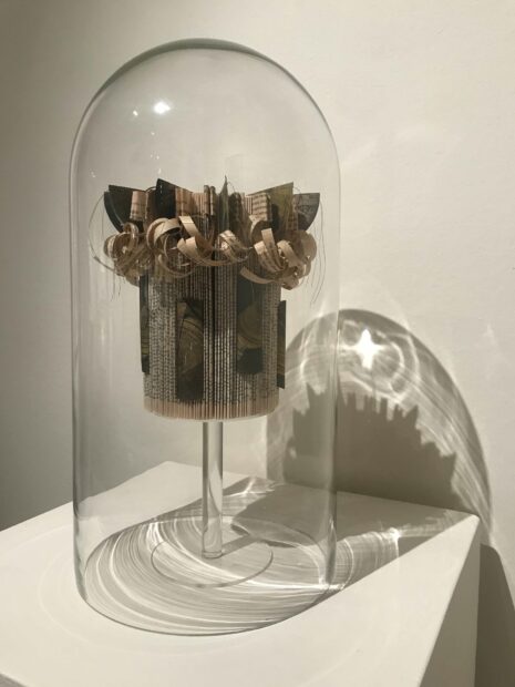 Installation image of a work made with paper in a round glass case