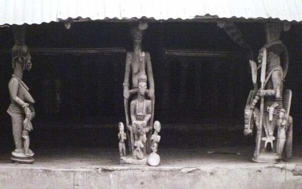 Black and white photo of three african sculptures in situ