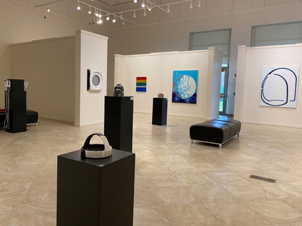 Exhibition view of sculptural work on black pedestals and 2D work on walls