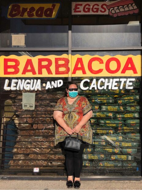 Photo of Maritza Bautista standing in front of a Barbacoa sign