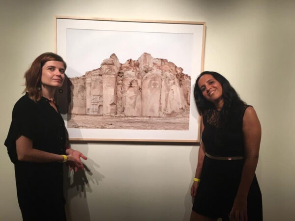 Dorota Biczel standing with an artist next to a print of a landscape