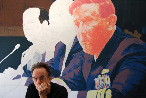 Ed Blackburn, seated in front of a painting in progress.