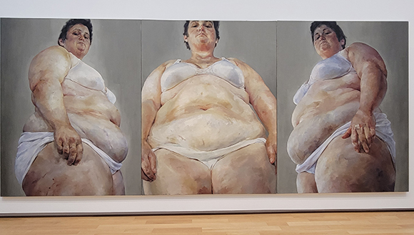 Three panel painting of the unaltered body of a woman painted from the perspective of the floor