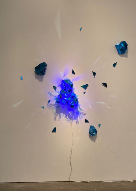 two dimensional sculpture exploding from a white wall