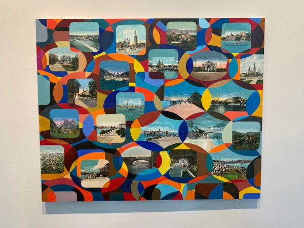 A photograph of a painting. The painting has postcards glued to its surface, and the artist has extended the scenes of the postcards beyond their boarders. The vignetted scenes are surrounded by circles of color.
