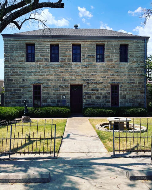 A photograph of the facade of The Old Jail Art Center in Albany, Texas. It is a two-story stone building.