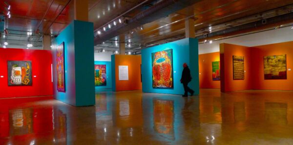 Installation view of large scale paintings on turquoise and yellow walls