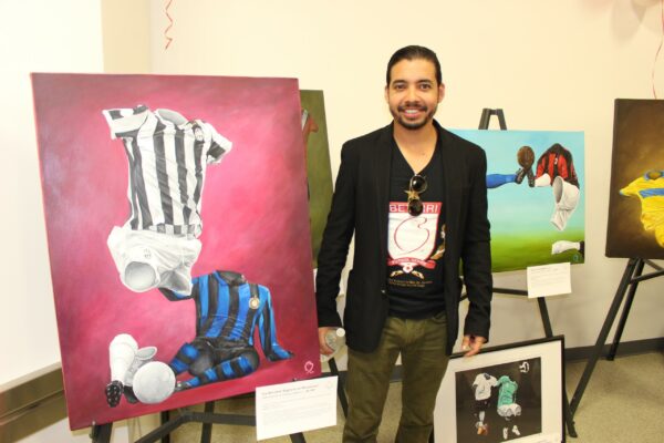 International artist Betirri stands in front of his artwork.