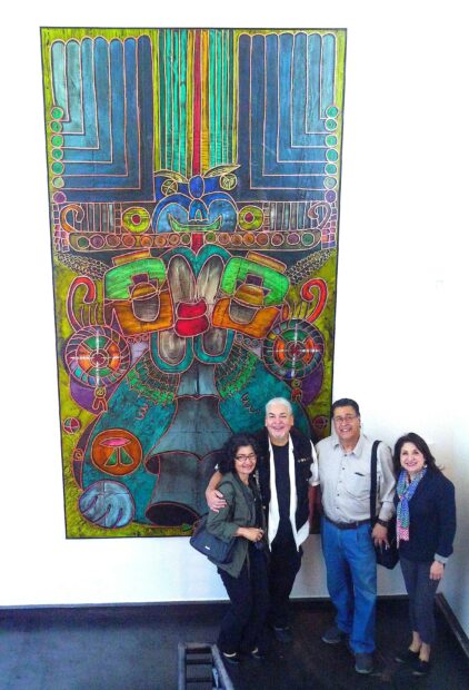 Photo of the artist with friends in front of a large paining