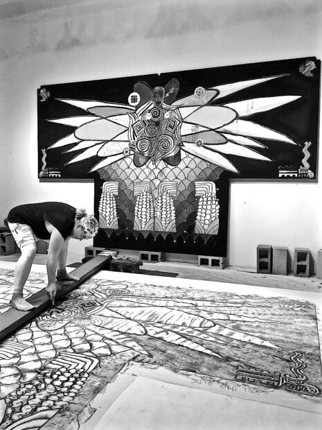 Photo of the artist working on a large scale drawing