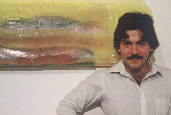 Photo of the artist in front of a yellow work