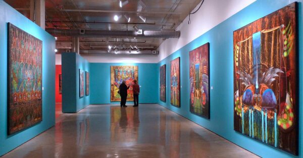 installation view of large scale paintings on a turquoise wall