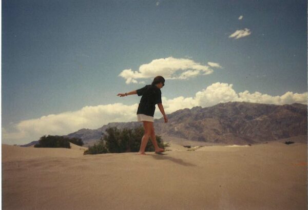 A photograph of Frances Colpitt walking in the desert.
